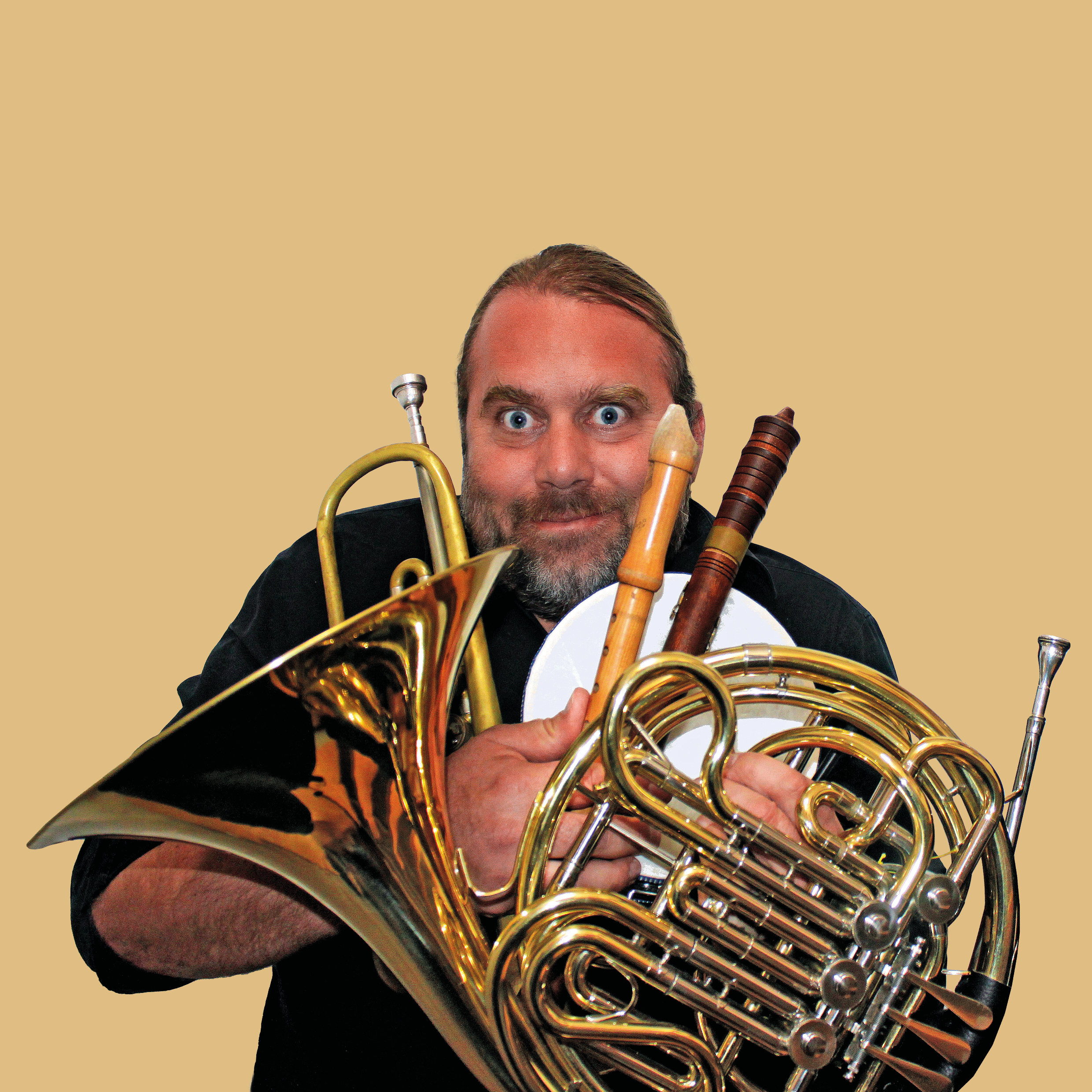 Der Musiker Andreas Martin Hofmeir hält in den Händen eine Trompet, ein Horn und verschiedene Flöten