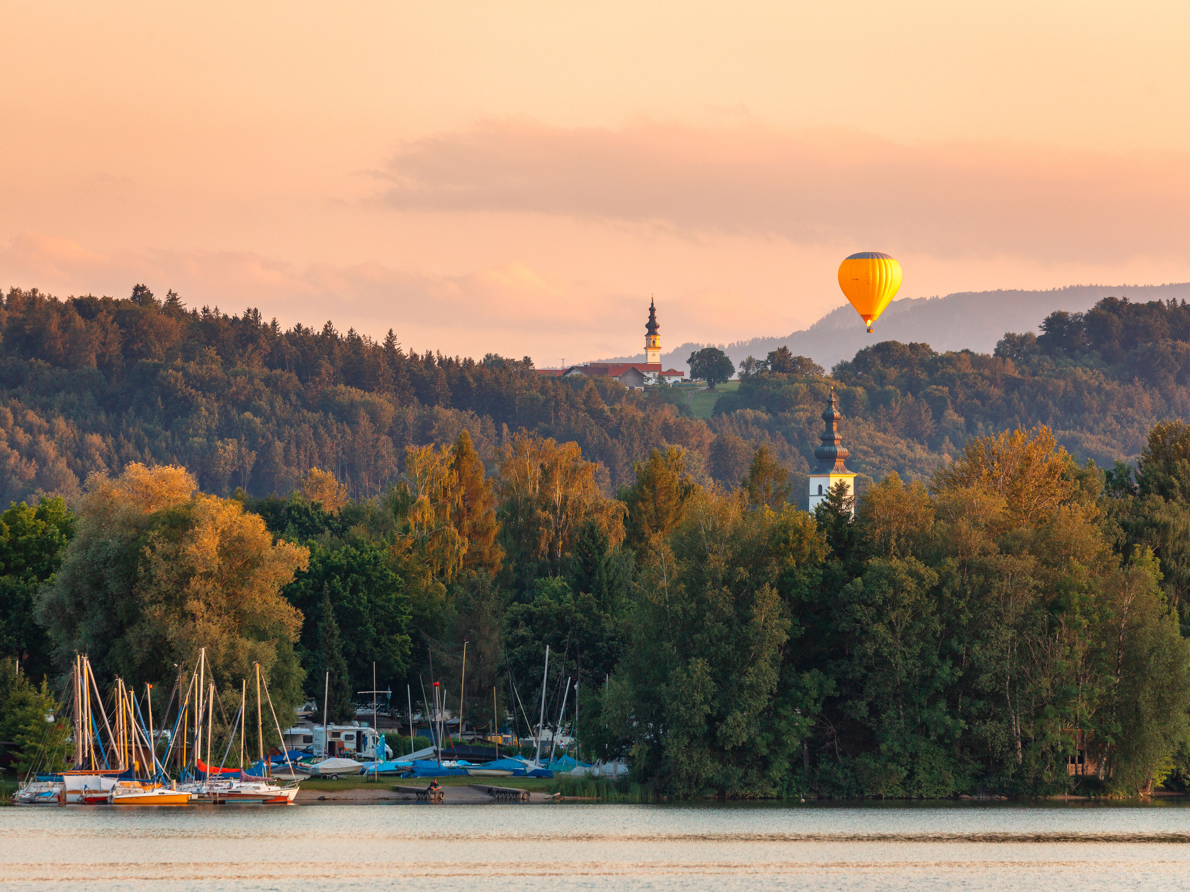 Sonnenuntergang am Waginger See mit Heißluftballon und Bootsanlegestelle